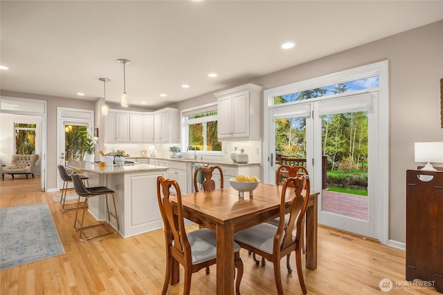 dining room with recessed lighting, baseboards, light wood finished floors, and visible vents