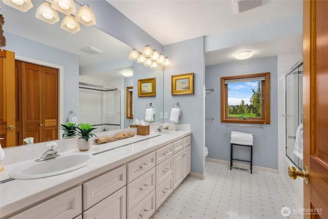 bathroom featuring double vanity, a sink, tile patterned floors, and toilet
