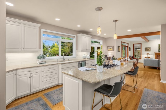 kitchen featuring recessed lighting, a sink, decorative backsplash, and white cabinets