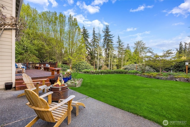 view of yard with a patio area, a fire pit, and a wooden deck