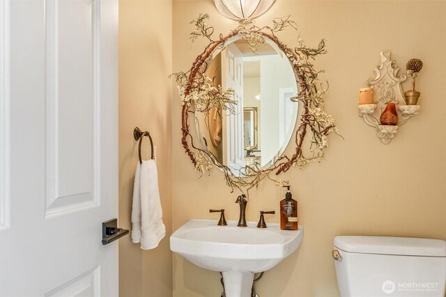 half bathroom featuring a sink and toilet