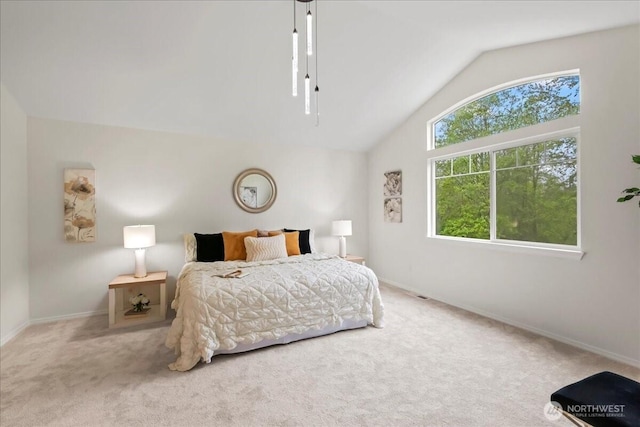 carpeted bedroom with baseboards and vaulted ceiling