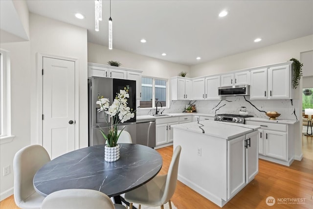 kitchen featuring white cabinets, stainless steel appliances, a sink, and tasteful backsplash