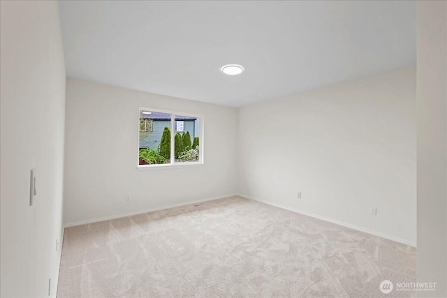 carpeted empty room featuring baseboards