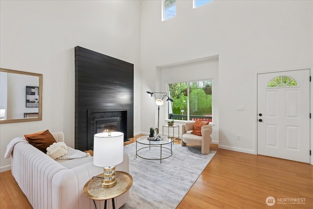 living room featuring plenty of natural light, a high ceiling, and wood finished floors