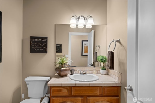 half bathroom with a chandelier, toilet, and vanity