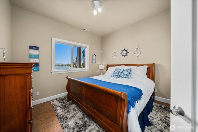 bedroom featuring visible vents, wood finished floors, and baseboards