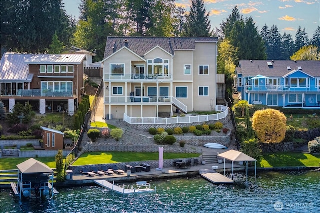 rear view of property featuring stairs, a water view, and a balcony