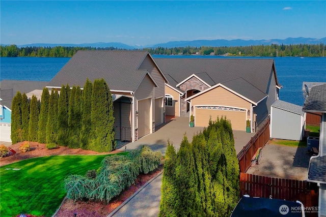 view of front of house featuring driveway, fence, central AC unit, and a garage