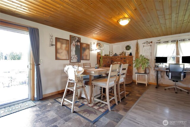 dining space featuring baseboards, wooden ceiling, and a healthy amount of sunlight