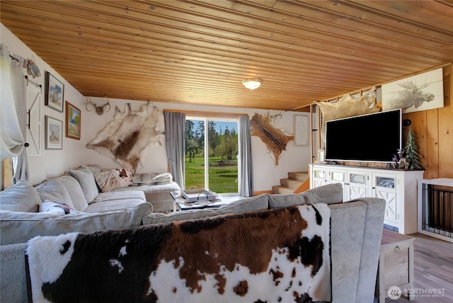 living area with wood ceiling, stairway, and wooden walls