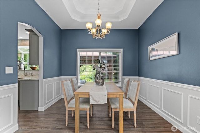 18431 Newport Dr, Arlington, WA 98223 - dining room with a tray ceiling, healthy amount of natural light, a chandelier, arched walkways, and a wainscoted wall