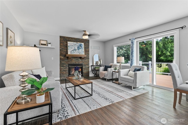 18431 Newport Dr, Arlington, WA 98223 - living area with wood finished floors, ceiling fan, and a stone fireplace