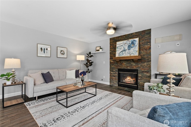18431 Newport Dr, Arlington, WA 98223 - living room with dark wood-style flooring, baseboards, a stone fireplace, and a ceiling fan