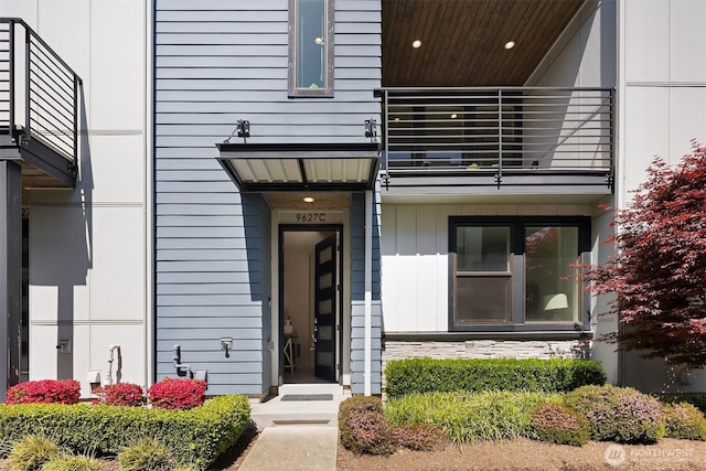 view of exterior entry with a balcony