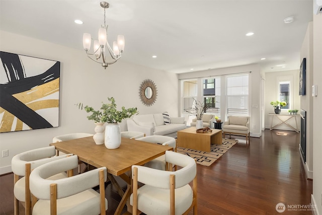 dining room featuring wood-type flooring, recessed lighting, and a notable chandelier