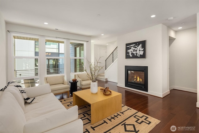 living area with stairs, recessed lighting, baseboards, and dark wood-type flooring