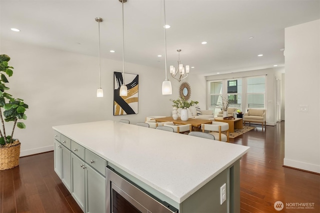 kitchen with baseboards, open floor plan, dark wood-type flooring, recessed lighting, and a center island