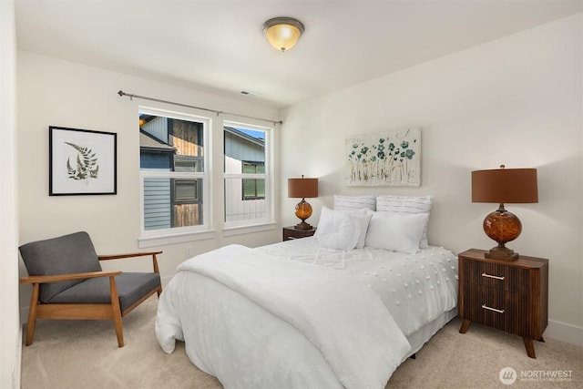 bedroom with baseboards and light carpet