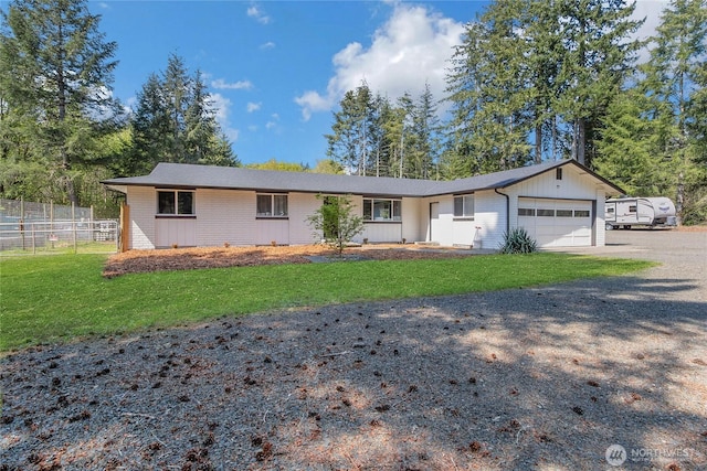 ranch-style house featuring board and batten siding, fence, driveway, a front yard, and an attached garage