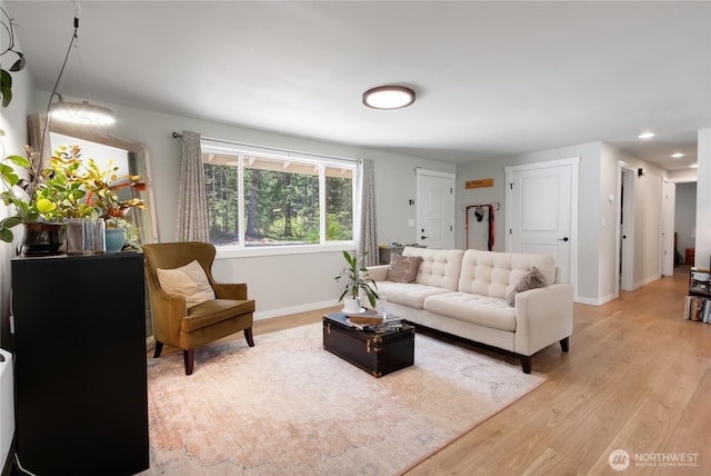 living area featuring baseboards, light wood-type flooring, and recessed lighting