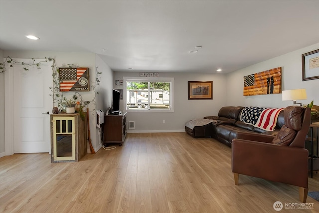living area with baseboards, light wood-type flooring, visible vents, and recessed lighting