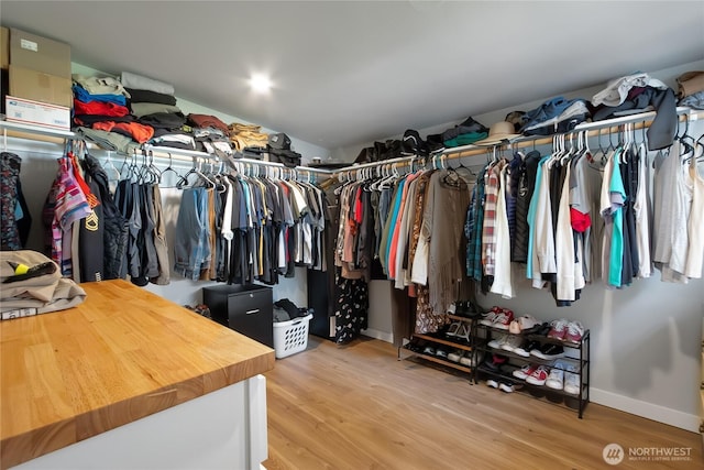walk in closet with wood finished floors