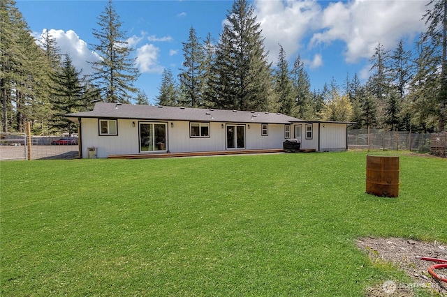 rear view of house featuring a fenced backyard and a yard