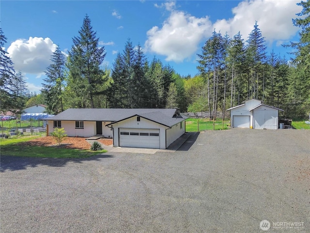 ranch-style home with driveway and fence