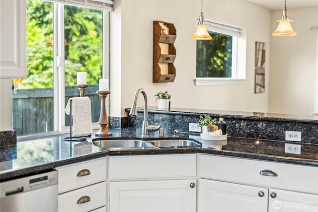 kitchen with decorative light fixtures, white cabinetry, stainless steel dishwasher, and a sink