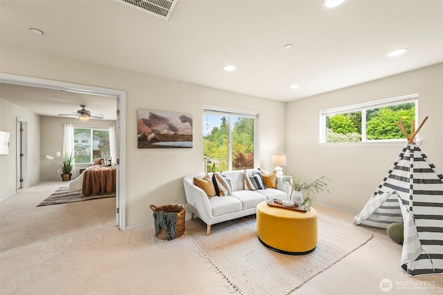 carpeted living area with baseboards, recessed lighting, and visible vents