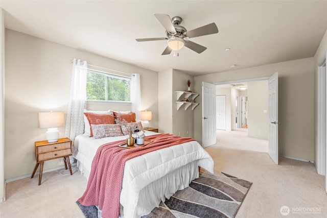 bedroom with light colored carpet, baseboards, and ceiling fan