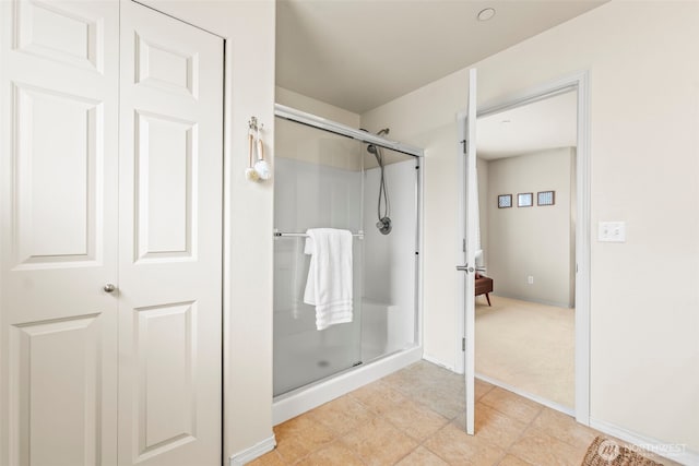 bathroom with baseboards and a shower stall