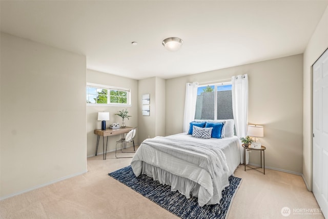 bedroom featuring light carpet and baseboards