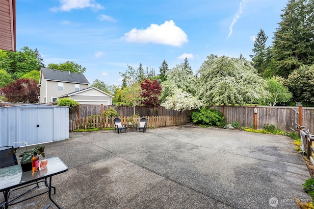 view of patio featuring a fenced backyard, an outbuilding, and a storage shed