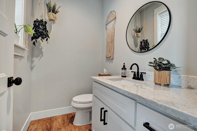 bathroom with vanity, baseboards, toilet, and wood finished floors