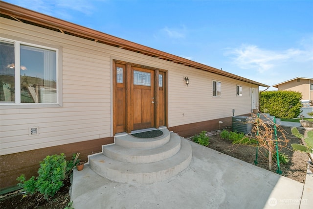 view of exterior entry featuring central AC unit