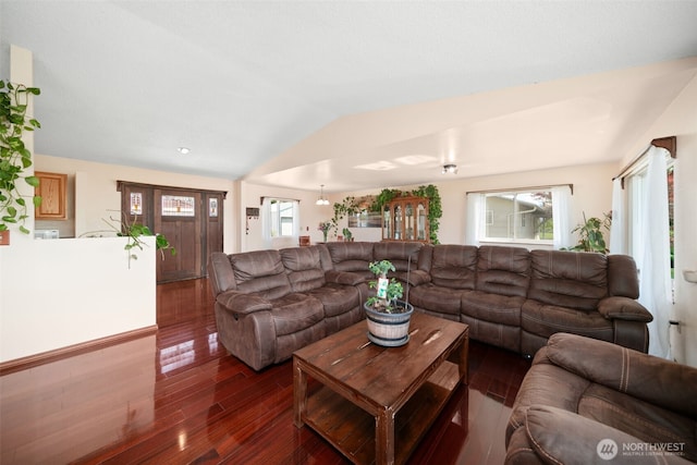living room featuring dark wood-style flooring and vaulted ceiling