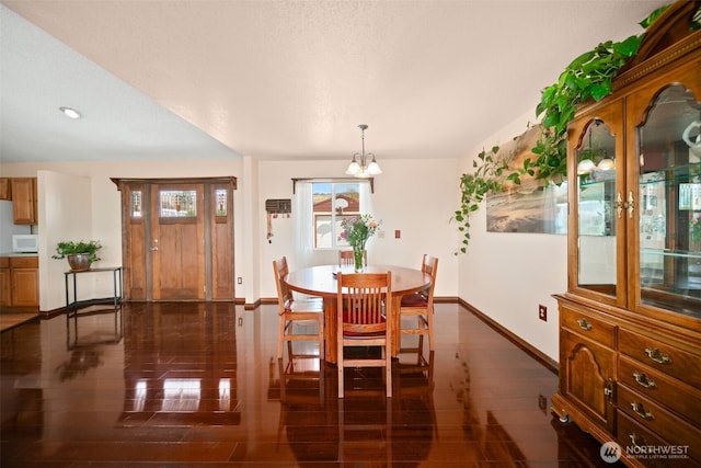 dining area featuring baseboards and a chandelier