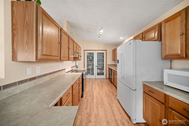 kitchen with white appliances, light wood-type flooring, light countertops, a textured ceiling, and under cabinet range hood