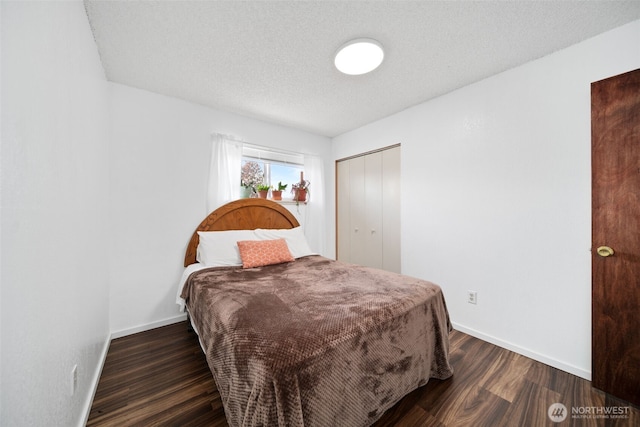 bedroom featuring baseboards, a textured ceiling, wood finished floors, and a closet