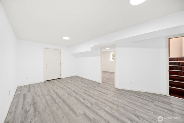 basement featuring light wood-style floors, baseboards, stairway, and recessed lighting