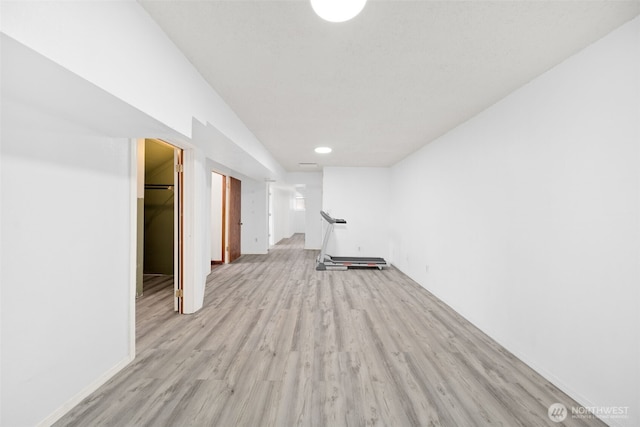 below grade area featuring recessed lighting, baseboards, and light wood finished floors