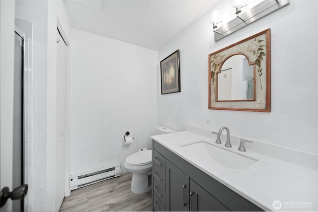 bathroom featuring vanity, a baseboard radiator, wood finished floors, and toilet