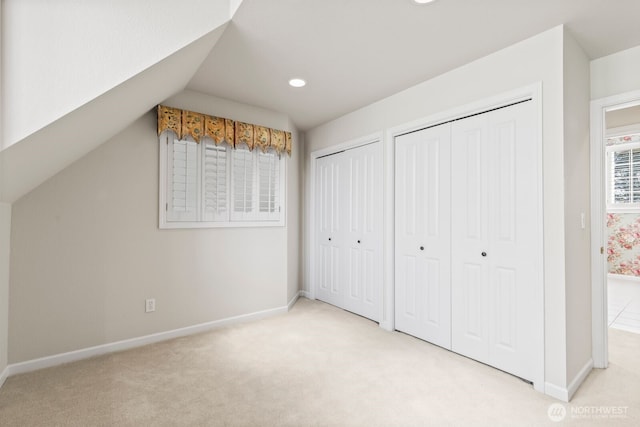 1208 N 20th Ave, Yakima, WA 98902 - unfurnished bedroom featuring multiple closets, vaulted ceiling, light carpet, and baseboards