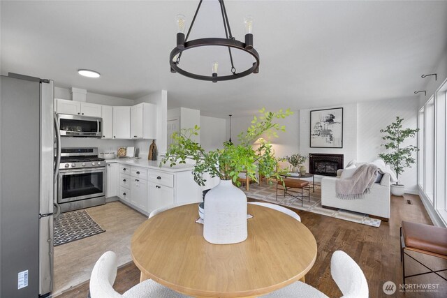 dining room with a glass covered fireplace and light wood-style flooring