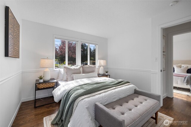 bedroom featuring a wainscoted wall and wood finished floors