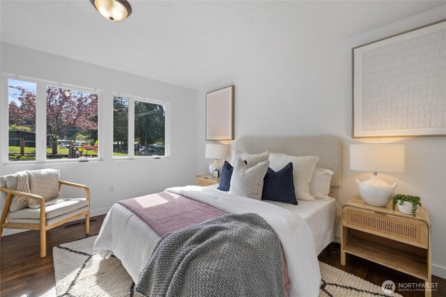 bedroom with baseboards and wood finished floors