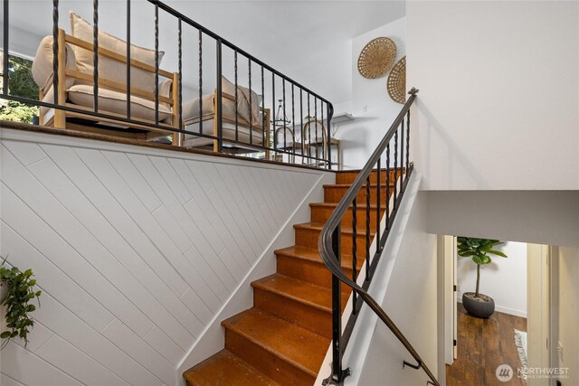 staircase featuring baseboards and wood finished floors