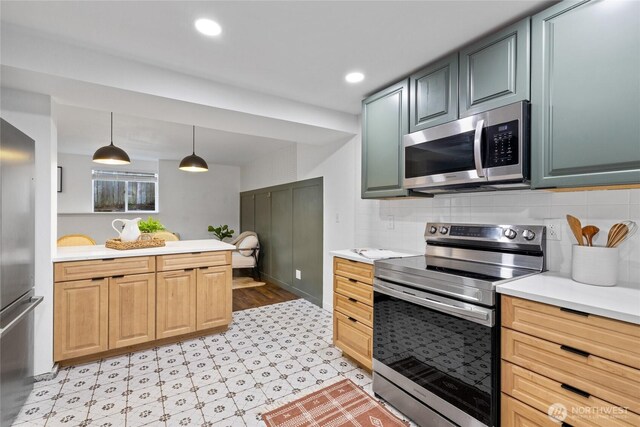 kitchen featuring light countertops, stainless steel appliances, backsplash, and light floors